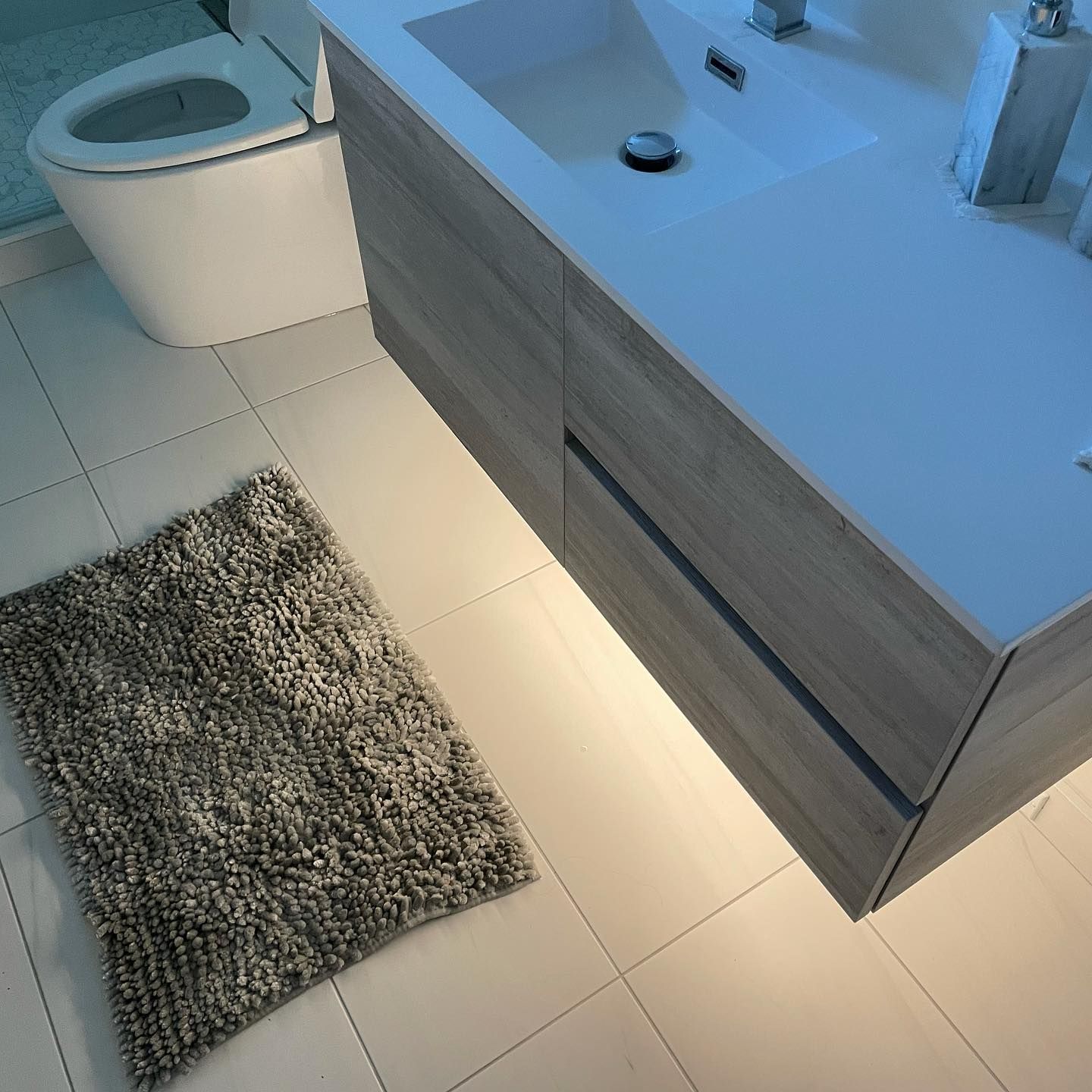 Renovated bathroom with floating vanity and under-cabinet lighting